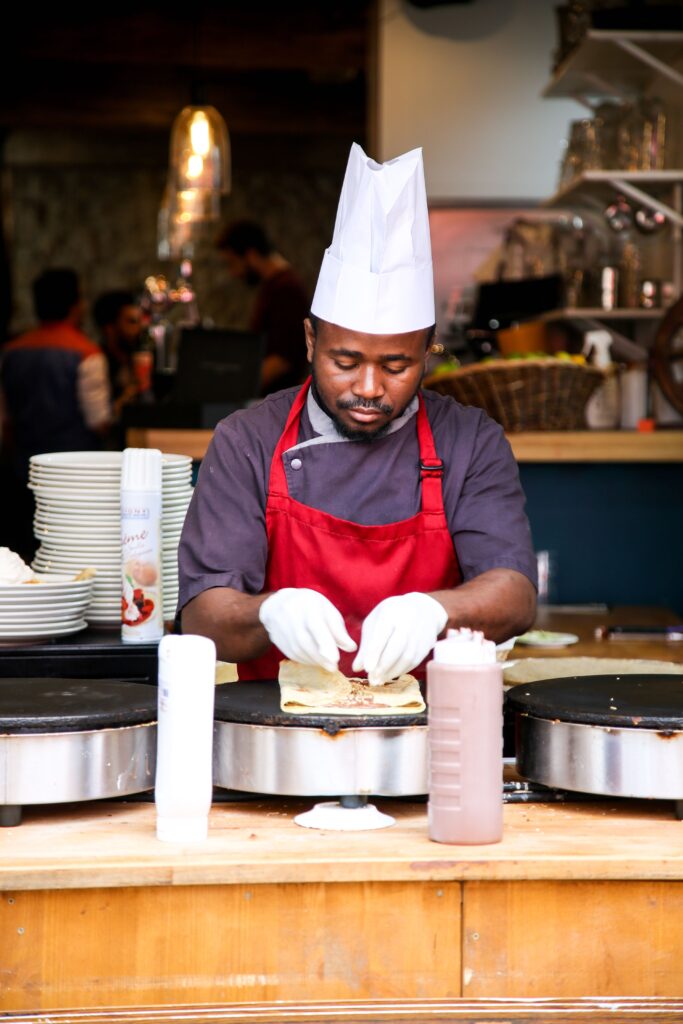 A chef preparing crepes in a dining hall.