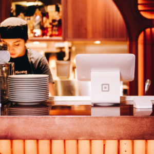 A female chef prepping plates at the restaurant counter